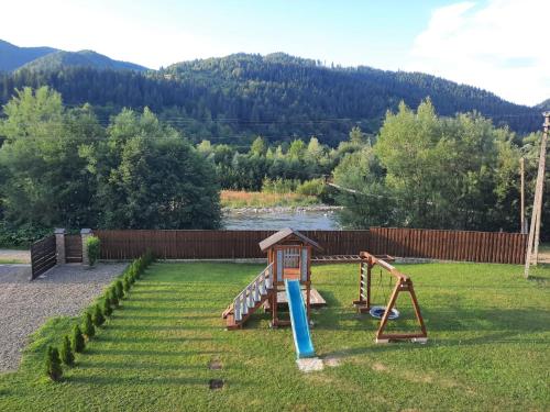 a yard with a playground with a slide at Карпатський двір in Krivorovnya