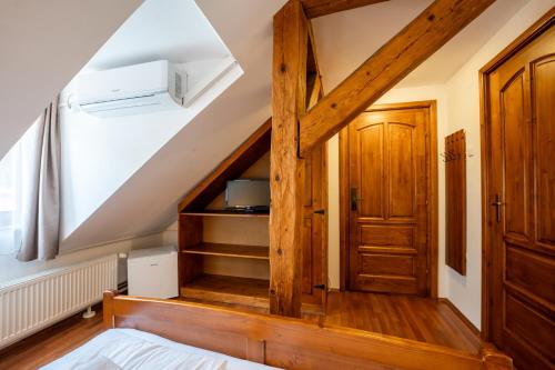 a room with a staircase with a wooden door at Pensiunea Bastion - La Strada - in Sighişoara