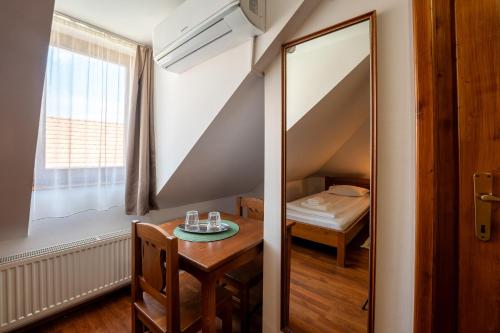 a room with a mirror and a table and a bed at Pensiunea Bastion - La Strada - in Sighişoara
