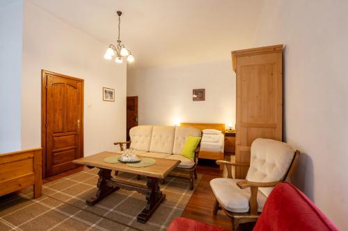 a living room with a couch and a table and chairs at Pensiunea Bastion - La Strada - in Sighişoara