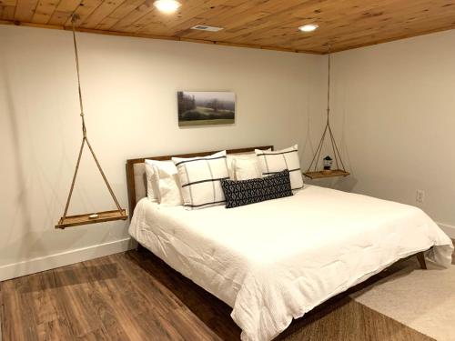 ヘンダーソンビルにあるFamily-Friendly Mountain Oasis W Game Room & Grillの白いシーツと枕が備わったベッドのある寝室