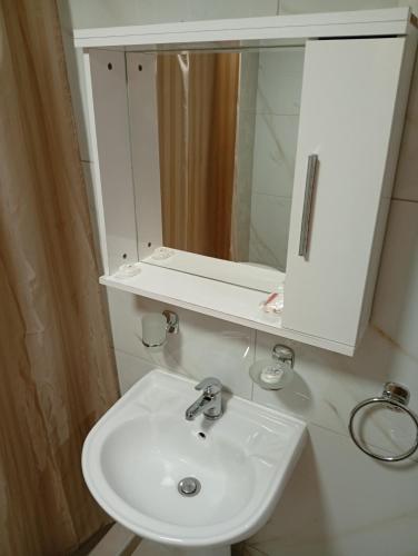 ein Badezimmer mit einem weißen Waschbecken und einem Spiegel in der Unterkunft Tournis in Chios
