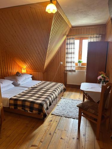 a bedroom with two beds and a table and a window at Pokoje Gościnne Stołowe in Gliczarów Górny