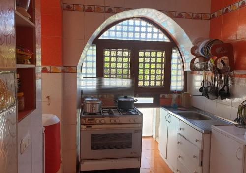 a kitchen with a stove and an arched window at Ma Sou in El Alamein