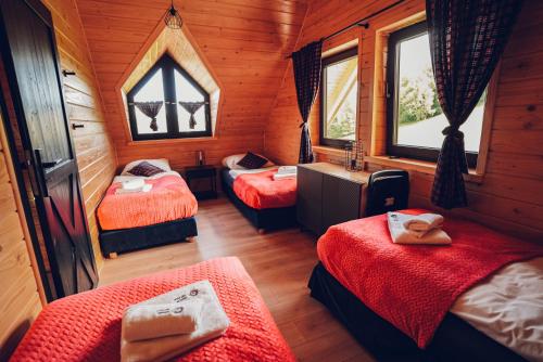 a room with three beds in a wooden cabin at Osada Kanada in Istebna
