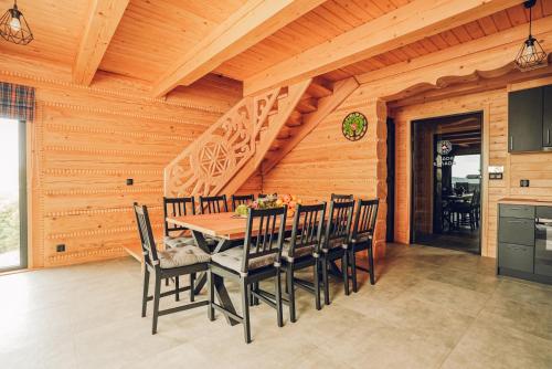 a wooden dining room with a table and chairs at Osada Kanada in Istebna