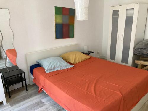 une chambre avec un lit avec une couverture orange dans l'établissement STRASBOURG PROCHE Petite France, à Strasbourg