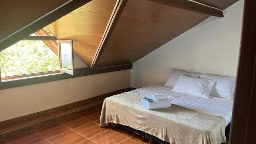 a bedroom with a bed and two windows at Pousada Cipó in Serra do Cipo
