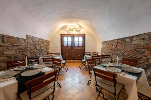 a dining room with tables and chairs and a stone wall at Pensiunea Bastion - La Strada - in Sighişoara