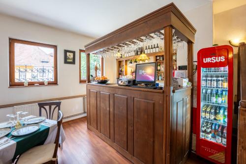 a restaurant with a bar with a red refrigerator at Pensiunea Bastion - La Strada - in Sighişoara