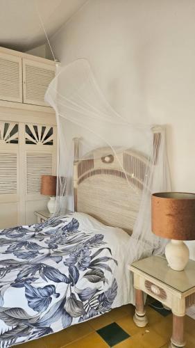 a bedroom with a bed with a canopy and a table at Villa Guadeloupe Saint François Accès Mer Piscine IGUANA BAY - Villa Zagadi in Saint-François