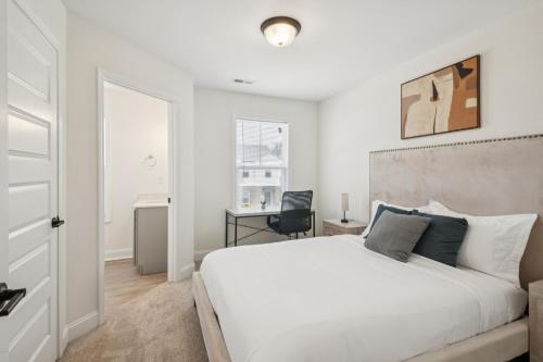 a bedroom with a white bed and a desk at Arte Luxury Townhomes K3 I Comfy 2 Bed 25 Bath in Oak Grove
