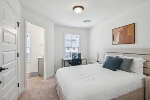 a bedroom with a large white bed and a desk at Arte Luxury Townhomes F6 I Comfy 2 Bed 25 Bath in Oak Grove