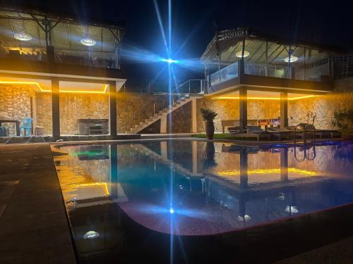 a large swimming pool at night with lights at Villa Le Pacha Assilah - Appartement in Asilah
