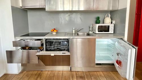 une cuisine avec un évier et un micro-ondes dans l'établissement Très beau Loft lumineux en plein coeur de Belleville, à Paris