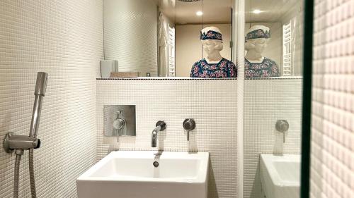une salle de bain avec un lavabo et deux mannequins dans un miroir dans l'établissement Très beau Loft lumineux en plein coeur de Belleville, à Paris