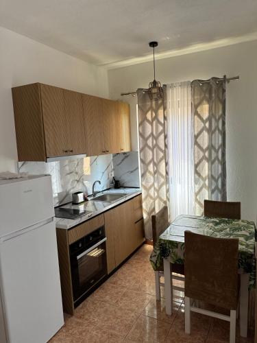a kitchen with a table and a white refrigerator at Guest House Kalaja in Durrës