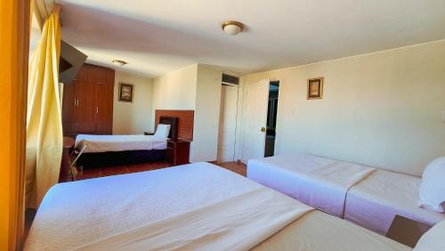 a hotel room with two beds and a bedroom at Manta Hotel Tacna in Tacna
