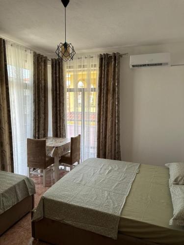a bedroom with a bed and a table with chairs at Guest House Kalaja in Durrës