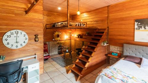 a room with a staircase and a clock on the wall at Bungalows Las Iguanas Arenal Volcano in Chachagua