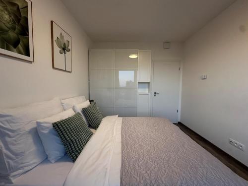 a bedroom with a white bed with pillows on it at Cozy Modern Apartment, 20 mins to Center in Prague