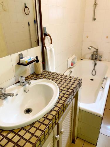 a bathroom with a sink and a tub at Frontline Holiday apartment in Durban