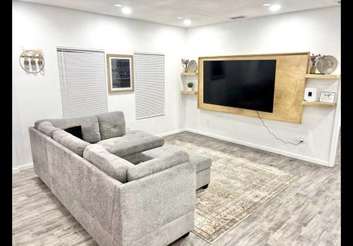 a living room with a couch and a flat screen tv at Kelly House in Pharr