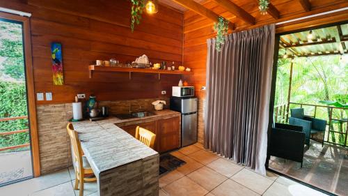 a kitchen with a counter and a stove top oven at Bungalows Las Iguanas Arenal Volcano in Chachagua