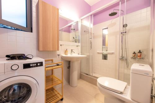 a bathroom with a washing machine and a sink at Sofi's Cozy House Near Athens Airport in Artemida