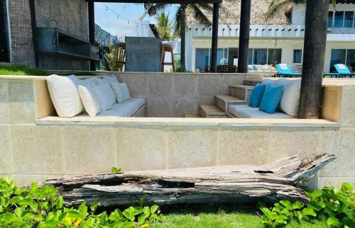 a patio with white and blue pillows on a wall at The sunrises are lovely, and the privacy is exceptional in Sipacate