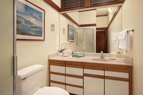 a bathroom with a sink and a toilet at Kiahuna Plantation Resort Kauai by OUTRIGGER in Koloa