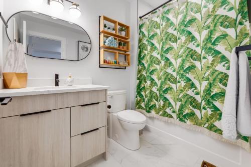 a bathroom with a toilet and a shower curtain at Santuario Kensington - Inner City Escape in Calgary