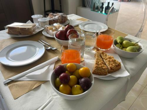 a table with plates of food and bowls of fruit at Regalpetra Hotel in Racalmuto
