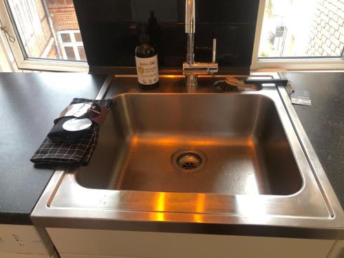 a stainless steel kitchen sink with a bottle of wine at Slotsgaarden ved Hesten in Randers