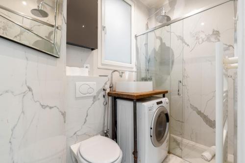 Un baño con inodoro y lavadora. en Arc de Triomphe Magnifique appartement, en París