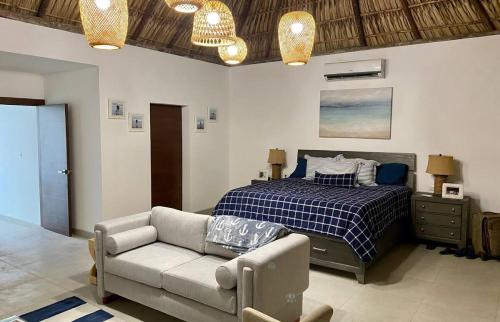 a bedroom with a bed and a couch and a bed at The sunrises are lovely, and the privacy is exceptional in Sipacate