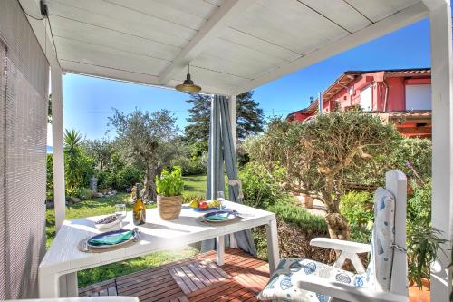 a patio with a white table and chairs on a porch at Casa Fra Gli Ulivi with Private Pool - Chicca in Ameglia