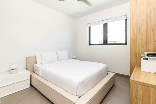 a white bedroom with a bed and a window at Luxury apartment in Grace Bay Beach in The Bight Settlements