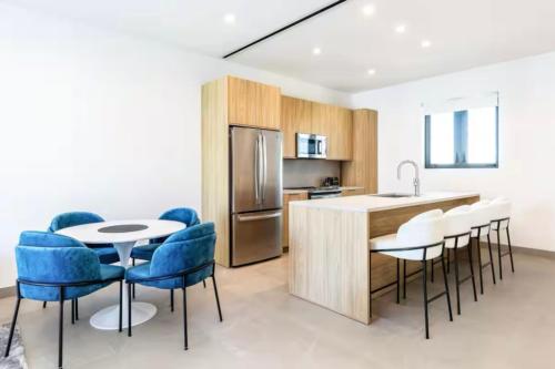 a kitchen with blue chairs and a table and a counter at Luxury apartment in Grace Bay Beach in The Bight Settlements