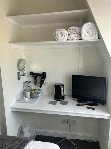 a desk with a computer monitor on a shelf at Black Swan Hotel in Kelso