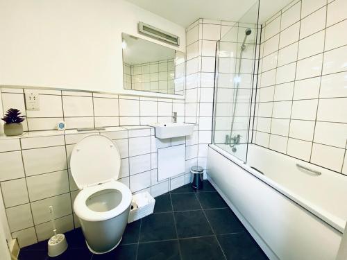 ニューキーにあるModern surf pad, steps from Towan beachのトイレ、浴槽、洗面台を備えたバスルーム