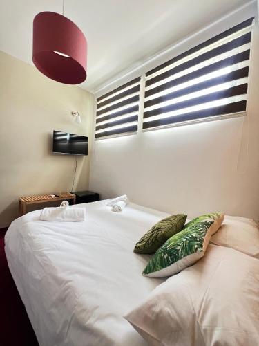 a bedroom with a white bed with green pillows at Sliema La Loggia Suites in Sliema