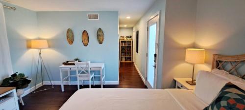 a bedroom with a bed and a table and a desk at Romantic Tropical Retreat with a Private Hot Tub! in Long Beach
