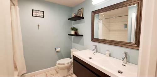 a bathroom with a sink and a toilet and a mirror at Romantic Tropical Retreat with a Private Hot Tub! in Long Beach