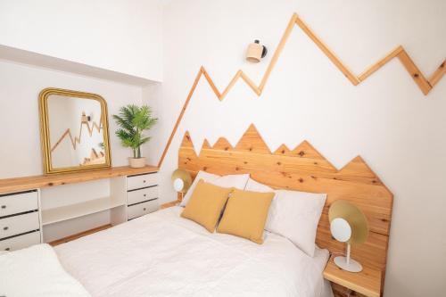 a bedroom with a white bed with a wooden headboard at Quinta Sao Roque in São Roque