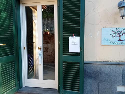 a green door of a building with a sign on it at L'Albero della vita in Piano di Sorrento
