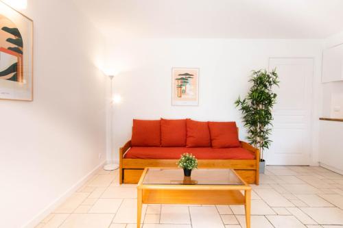 a living room with a red couch and a table at Appartement 52 4-6 personnes plages à pied in Capbreton