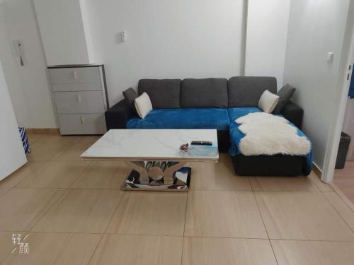 un salon avec un canapé bleu et une table basse dans l'établissement 休闲民宿, à Paris
