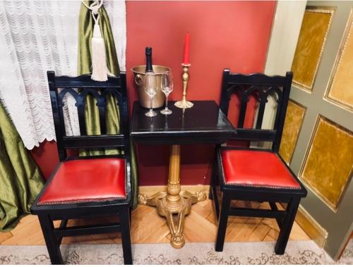 a table with two chairs and a desk with a candle at Classic Love Story in Old Cluj III in Cluj-Napoca