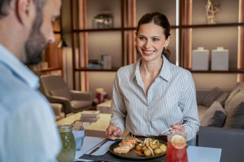a woman sitting at a table with a plate of food at AC Hotel by Marriott Lima Miraflores in Lima